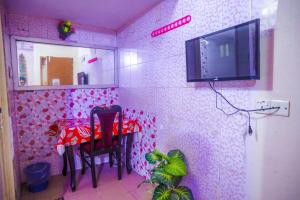 达卡Hotel Victoria Inn (Nazimuddin Road)的一间设有桌子的房间和墙上的电视
