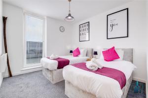 伯明翰City View Apartments的白色客房内的两张床和粉红色枕头