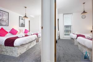 伯明翰City View Apartments的一间卧室配有3张带粉红色枕头的床