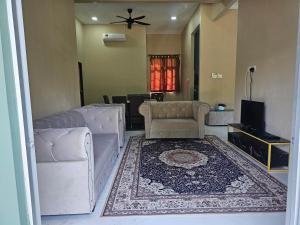 TumpatHomestay D'Bunohan的带沙发和地毯的客厅