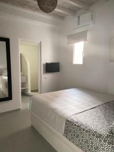 圣斯特凡诺斯Mykonian Luxury Villa Azure w Sea View and Pool的一间白色卧室,配有床和电视