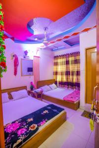 达卡Hotel Victoria Inn (Nazimuddin Road)的一间卧室设有两张床,天花板设有灯光。
