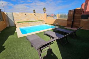 La GuirraEl Castillo Golf Salinas-wifi的一个带2个长凳和桌子的游泳池