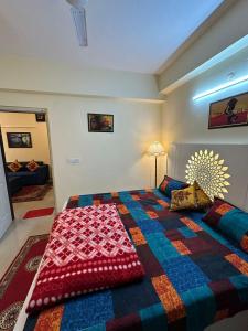 加济阿巴德Royal Ambience的一间卧室配有一张大床和色彩缤纷的毯子