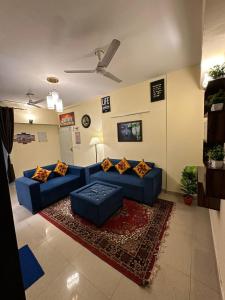 加济阿巴德Royal Ambience的客厅配有蓝色的沙发和地毯。