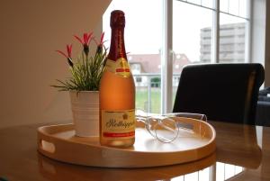 奥斯特巴特宁哈根Exkl App Kliff am Meer, W-LAN, Balkon的桌子上摆放着一瓶香槟酒,配杯