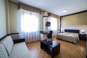 菲登扎阿索托丽亚酒店的酒店客房设有一张沙发和一张床