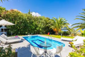 卢特拉Villa Sevos的一个带桌椅的游泳池和一个游泳池
