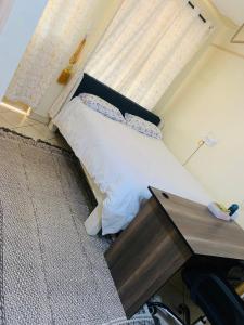 内罗毕SOMI'S Suites的一间卧室配有一张带窗户的床和一张书桌