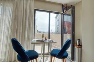 伊斯坦布尔GALATAGREENAPPLEHOTEL的客房设有一张带蓝色椅子的桌子和一扇窗户。
