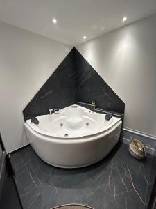 La FouillouseChâteau Le Fournel的黑色墙壁浴室内的白色大浴缸
