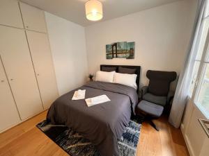 波尔多Beautiful Apartment in City Center的一间卧室配有一张床和一把椅子