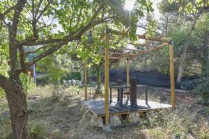 拉蒂尔比耶Wood Chalet 1 Monaco Forest La Turbie - Sleeps 5 people的木结构,坐在树下