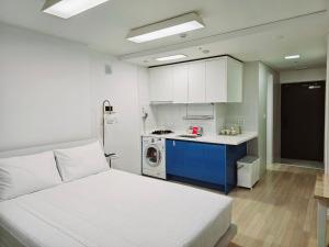 釜山Jeoung's House的一间带白色床的卧室和一间厨房