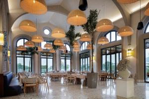 达特恰Palaia Hotel Datça的用餐室配有桌椅和吊灯。