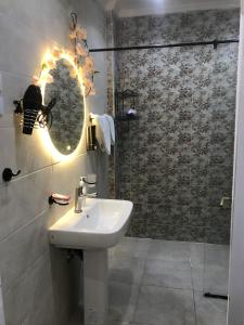 开罗Yacoubian Suites的浴室配有盥洗盆和带镜子的淋浴