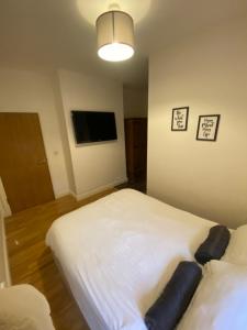 莱斯特Midland Apartments- one bedroom的一间卧室配有两张床和一台平面电视