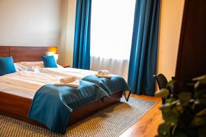 佩济诺克罗扎尔卡酒店的一间卧室配有一张带蓝色窗帘的床和一扇窗户