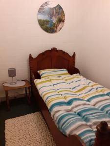 巴特萨尔茨乌夫伦Ruhiges Ferienhaus im Garten的卧室内的一张床铺,墙上挂着一个时钟