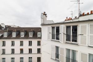 巴黎Agréable studio cœur de paris - Paris 6 - 2P的一组建筑,有白色的窗户和屋顶
