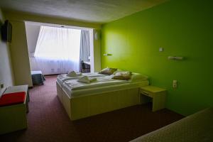 迪马诺卡多林纳Hotel OSTREDOK的绿色的客房设有床和窗户。