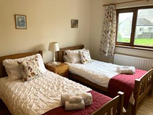 UldaleEmerald Bank Cottage的一间卧室设有两张床和窗户。
