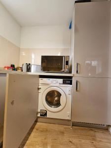 考文垂Cosy & Stylish One-Bed Flat-close to Warwick Uni的厨房配有洗衣机和冰箱。