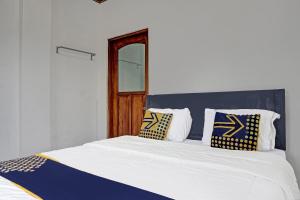 苏加武眉Super OYO 2226 Nurmega Jaya的一张带蓝色和白色枕头的床