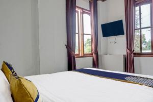 苏加武眉Super OYO 2226 Nurmega Jaya的一间卧室配有一张带白色床单和窗户的床。