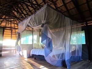 利文斯顿Sukulu Reserve的小屋内一间卧室配有一张天蓬床
