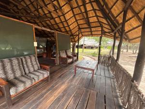 利文斯顿Sukulu Reserve的木甲板上设有1个带沙发和桌子的门廊