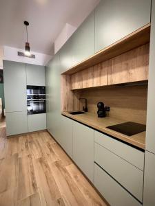 科尔多瓦Tabor的厨房铺有木地板,配有白色橱柜。