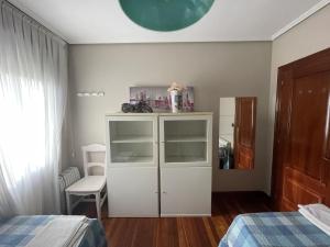 洛乌Habitación Aeropuerto Loiu的卧室配有白色橱柜和1张床