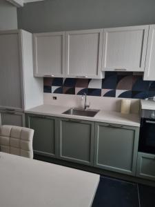 米兰PM 410 Via Delle Forze Armate Guest House的厨房配有白色橱柜和水槽