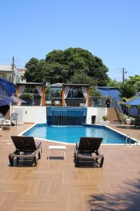 伊瓜苏Hotel Portinari Centro的游泳池前设有2张躺椅