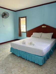 甲米镇Adam Bungalows的卧室内的一张大床,卧室内有蓝色的墙壁