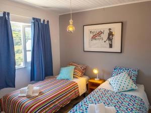 CarvoeiraHouse beach in Lizandro by Ericeira Property的一间卧室设有两张床,窗户配有蓝色窗帘