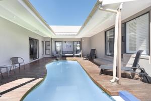 开普敦Villa Balmoral 14 by HostAgents的客厅设有游泳池,配有桌椅