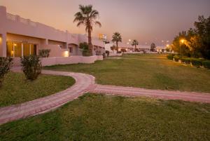 科威特Copthorne Al Jahra Hotel & Resort的棕榈树建筑前的走道