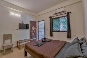 卡兰古特Rosa Bella Resort-TBV的卧室配有一张床,墙上配有电视。