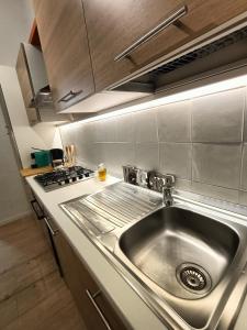 蒙扎Cozy Apartment in Monza City Center的厨房配有不锈钢水槽和炉灶。