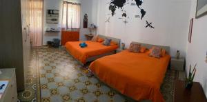 瓦莱塔Sunrise Apartment的配有橙色床单的客房内的两张床