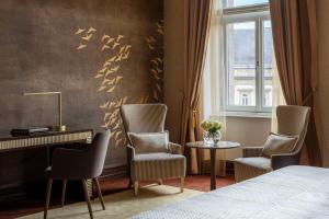 布达佩斯Anantara New York Palace Budapest - A Leading Hotel of the World的一间卧室配有一张床、两把椅子和一张书桌