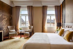 布达佩斯Anantara New York Palace Budapest - A Leading Hotel of the World的酒店客房,配有一张床和两把椅子
