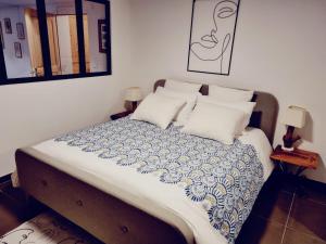 NeuvecelleLogement avec billard, home cinéma et terrasse privatisés的一张带蓝色和白色毯子及枕头的床