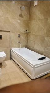 齐拉克普尔HOTEL PEARL WOOD (A unit of olive hospitality group)的带浴缸和卫生间的浴室。