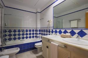 弗龙特拉堡Hotel Tugasa Castillo de Castellar的一间带水槽、卫生间和镜子的浴室