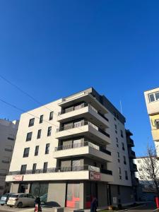 巴尼亚科维利亚查Vila Drina Apartments的一座高大的公寓楼,前面的人在步行