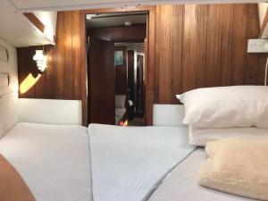卡列罗港Marina Oasis, Your Boatel的一间卧室设有两张白色的床和木墙