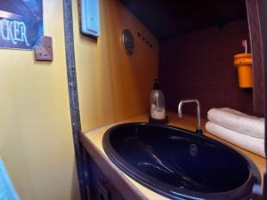 圣米格尔德阿沃纳The Captains Locker - 30ft Yacht的浴室设有黑色水槽和1瓶肥皂。